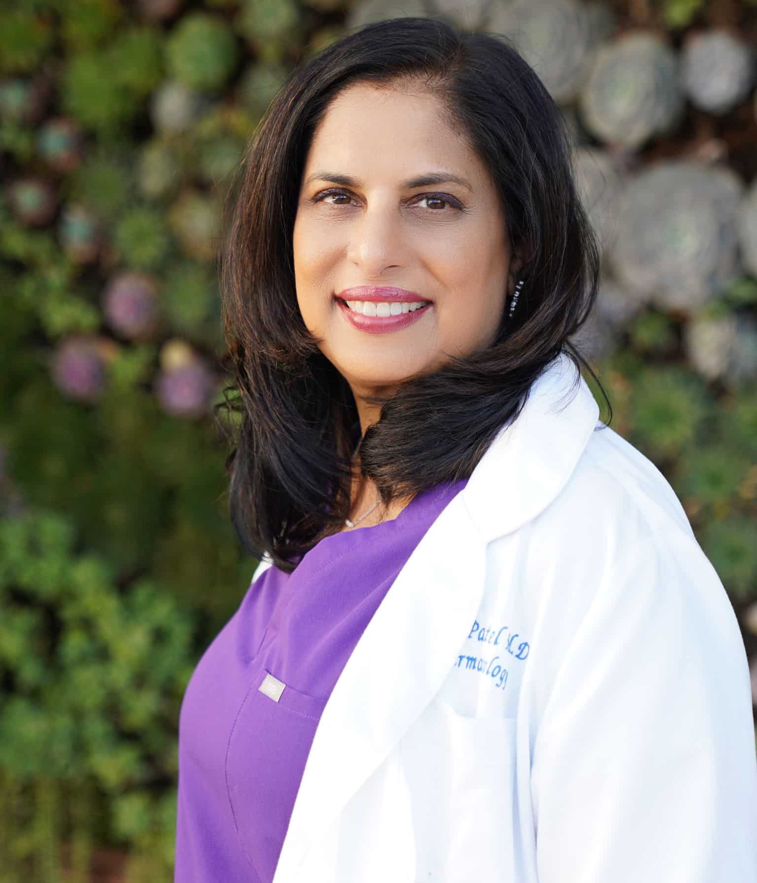 Portrait of Dr. Nita Patel, MD, in a white coat over purple scrubs